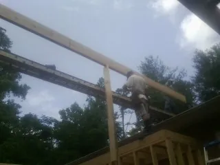 Carpenter setting a ridge beam over a new addition frame — Ice Dam Removal by Roofing Brothers in Fort Riley